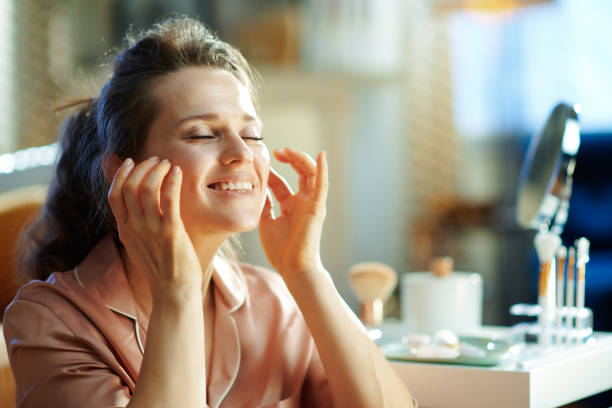 istock happy stylish woman applying cream and making massage 1210089530