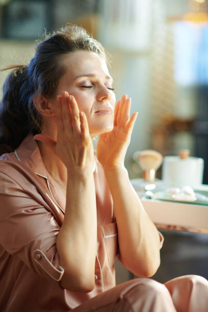 istock relaxed stylish housewife applying cream and making massage 1210089534