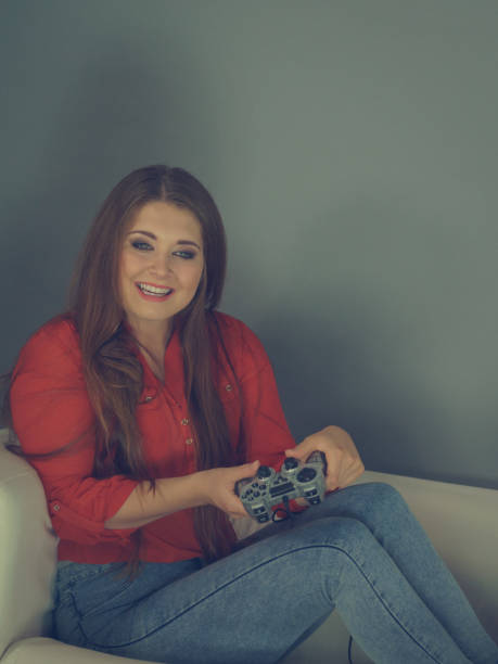 istock Young woman playing video games 1210089688