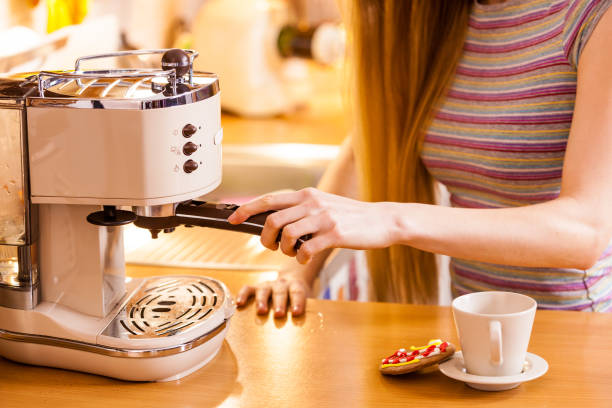 istock Woman in kitchen making coffee from machine 1210090120
