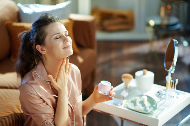 istock relaxed woman with jar applying neck cream 1210090908
