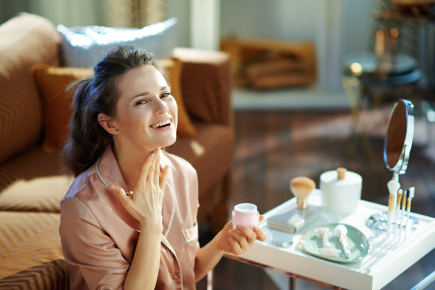 istock smiling woman with jar applying neck cream 1210091056