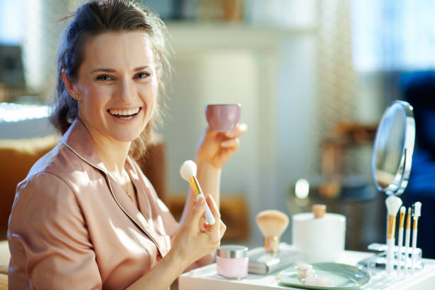 istock happy elegant female with white makeup brush drinking coffee 1210091060
