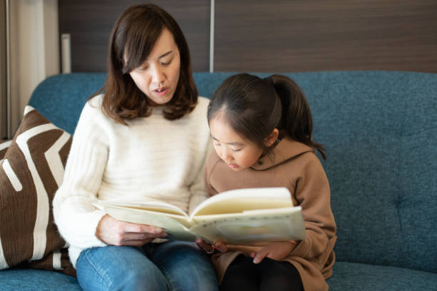 istock Mother reading book to daughter at home 1210091259