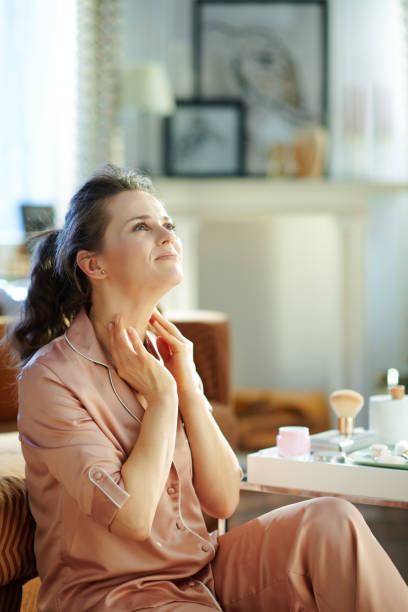 istock smiling modern housewife applying neck cream 1210094068