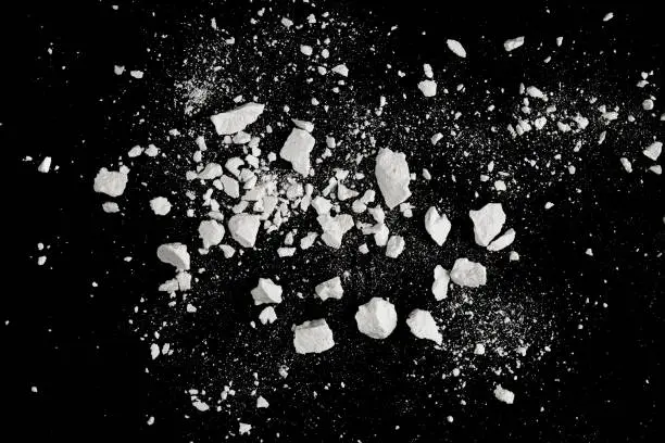 Photo of Rock stone broken splash explosion isolated on black background