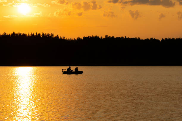istock Fishermen catch fish on the lake at sunset. 1210096074