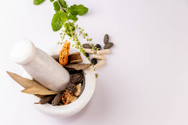 collection de différentes épices dans le pilon de mortier et les comprimés de fines herbes avec des feuilles de tulsi sur le fond blanc - cardamom cinnamon mortar and pestle herb photos et images de collection