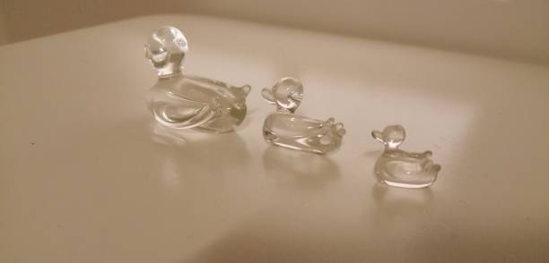 Glass ducks on a white table. They once belonged to my beloved grandma.