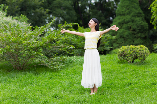 lovely beautiful chinese girl on the lawn to watch the landscape