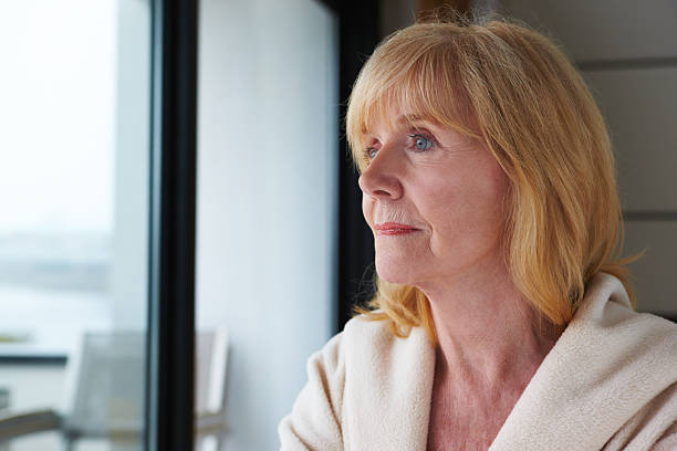 istock Senior Woman Pensively Looking Out a Window 121010926