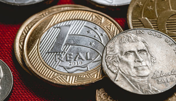 istock Brazilian coins and Us Coins on a table. 1210113355