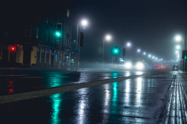 voiture solitaire dans la nuit après la pluie - night wet road street photos et images de collection