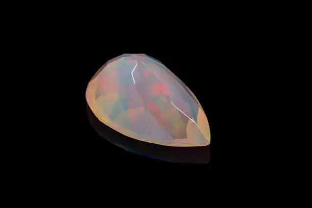 Photo of macro mineral stone faceted opal on a black background