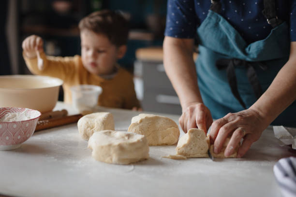 istock Grandmother cutting dough into small pieces 1210115750