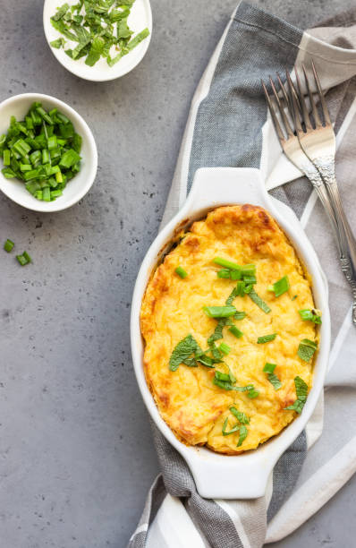 Potato casserole with fish and cheese on a light grey background.