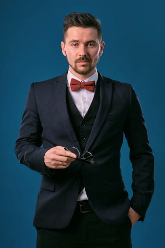 Young Business Man In Classic Black Suit White Shirt And Red Bowtie Posing  Against A Blue Studio Background Mock Up Copy Space Closeup Stock Photo -  Download Image Now - Istock