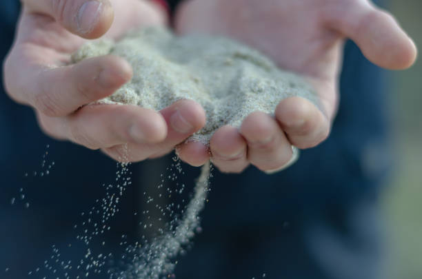 istock Sand pours through fingers. 1210118463