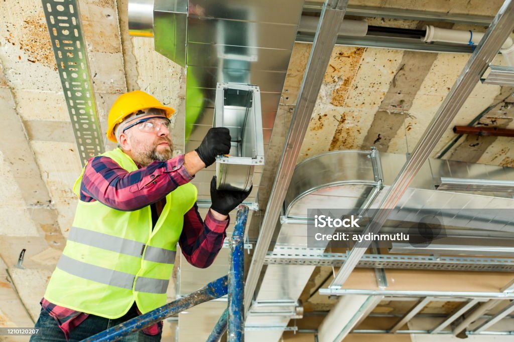 Manual Worker  installing air conditioner in building Manual Worker  installing air conditioner in building. Air Duct Stock Photo