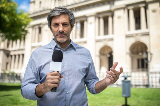 Adult man holding microphone, reporting from  Buenos Aires, Argentina