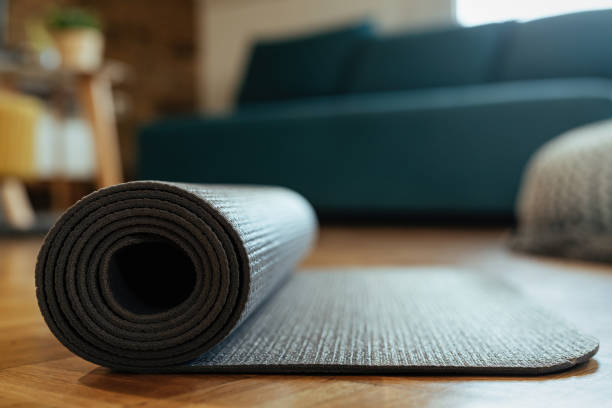 istock Close-up of rolled exercise mat on parquet floor. 1210121263