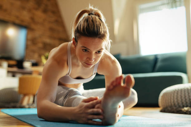 istock Young female athlete stretching her leg on the floor. 1210121569