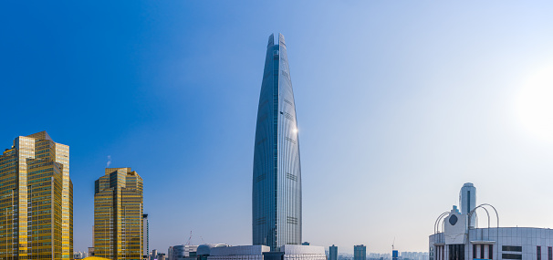 The futuristic spire of the Lotte World Tower gleaming the sunlight high of the skyline cityscape of central Seoul, South Korea’s vibrant capital city.