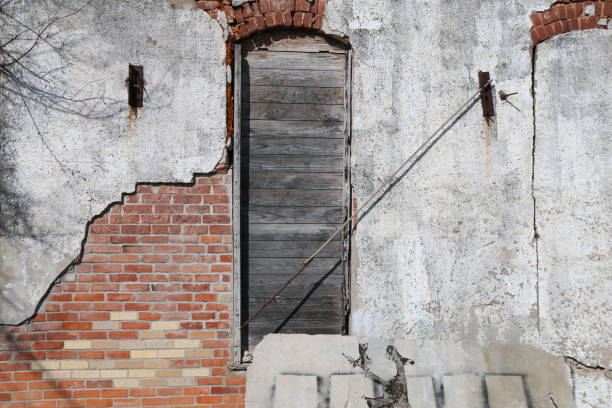 istock boarded up arched window stucco red brick wall building 1210123468