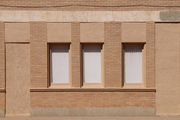 istock retro old windows brown brick warehouse office building shadows 1210123485