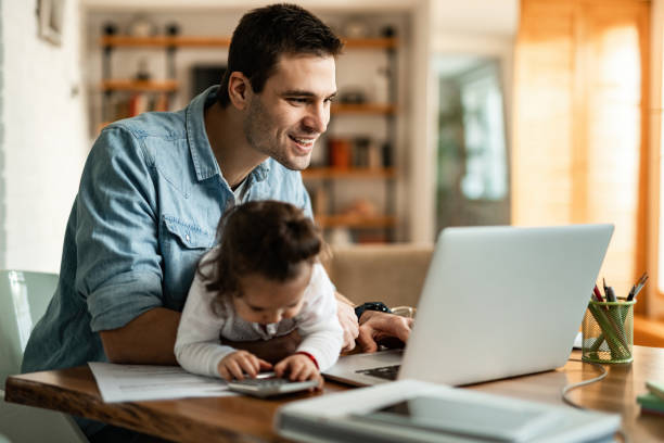 szczęśliwy ojciec pracuje na laptopie będąc z małą córką w domu. - love internet business e mail zdjęcia i obrazy z banku zdjęć