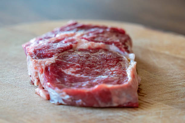 istock Raw steak on wooden table 1210129499