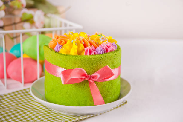 istock Spring Easter festive table. Small green cake with butter cream flowers and colorful eggs on the background. 1210130200