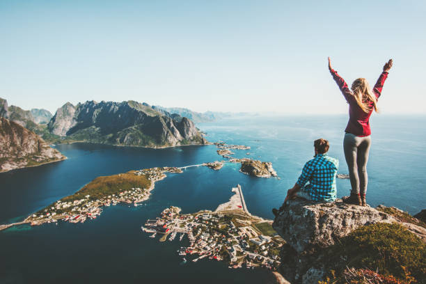 pareja familia viajando juntos en el borde del acantilado en noruega hombre y mujer estilo de vida concepto de verano vacaciones al aire libre vista aérea lofoten islas reinebringen cima de la montaña - lofoten fotografías e imágenes de stock