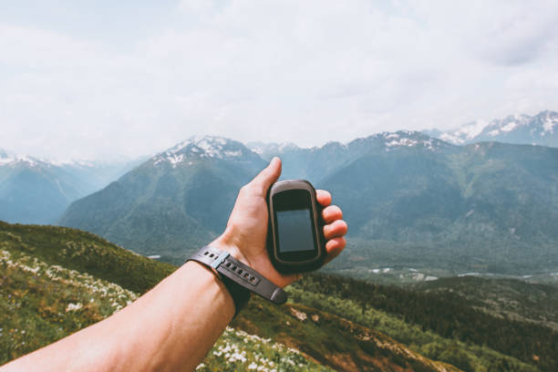 istock Traveler hand holding gps navigator tracker looking for location coordinates hiking in mountains Travel Lifestyle concept survival adventure summer vacations outdoor 1210134149