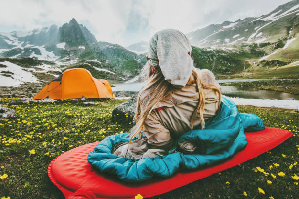 山の中で旅行休暇をキャンプ赤いマットの寝袋でくつろぐ女性 ライフスタイルコンセプトアドベンチャー週末屋外野生の自然 - スリーピングバッグ 写真 ストックフォトと画像