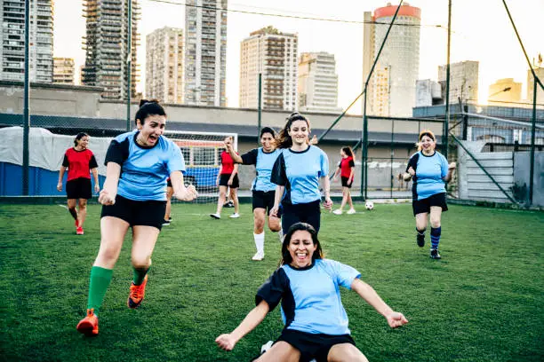 Photo of Excited Hispanic female footballers celebrating goal
