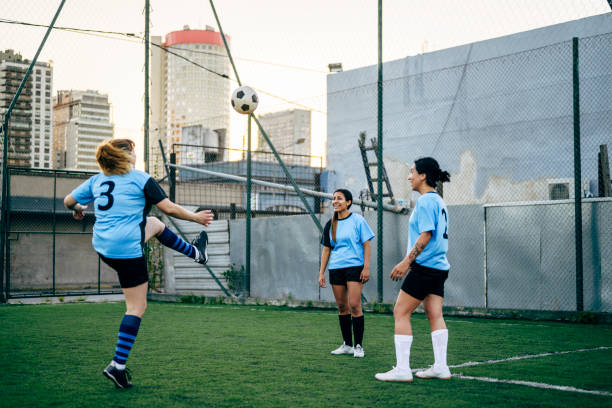 istock Hispanic footballers in their 20s kicking ball between them. 1210136772