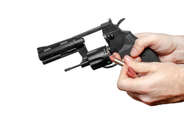 istock Hands of a man loading a black revolver with a thrown drum 1210140315