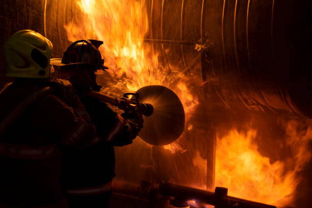 istock 2 firefighters spraying high pressure water to fire 1210140783