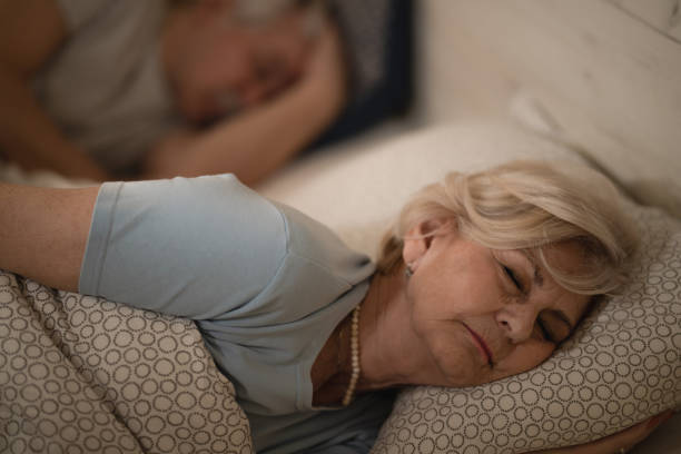 istock Tired mature woman sleeping in bed at night. 1210140834
