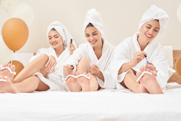 istock Female friends in bathrobes doing pedicure. 1210140954