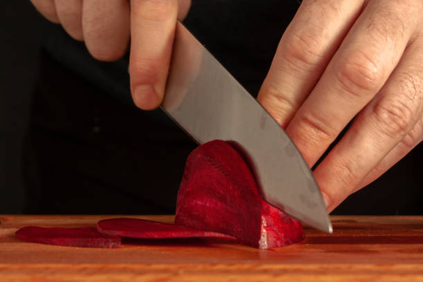 istock Men 's hands are sliced with a cook 's knife fresh beet on a cutting board 1210142604