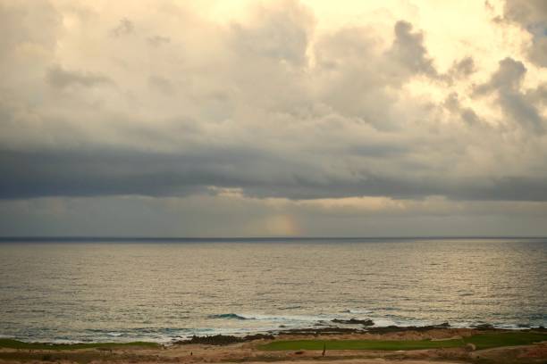istock Moody clouds with rainbow over water 1210144437