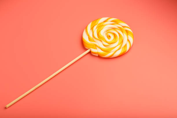 Colorful round Lollipop on pink background. Minimal concept with copy space. Confectionery, sweets