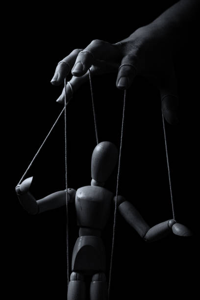 istock Conceptual image of a hand with strings on fingers to control a marionette in monochrome 1210145090