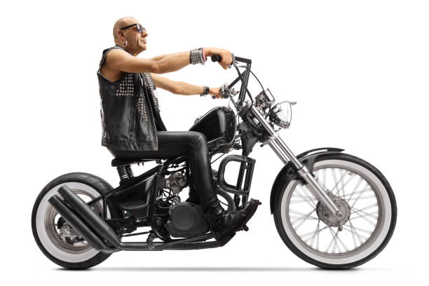 istock Bald biker riding a custom chopper motorbike 1210146573