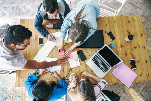 istock overhead view on business people working together on desk 1210148736