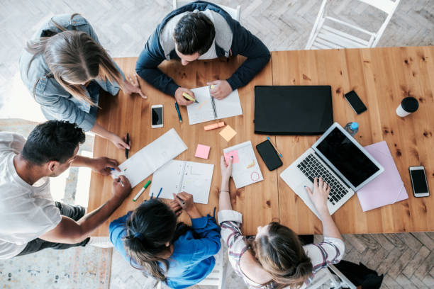 istock overhead view on business people brainstorming together on desk 1210149350