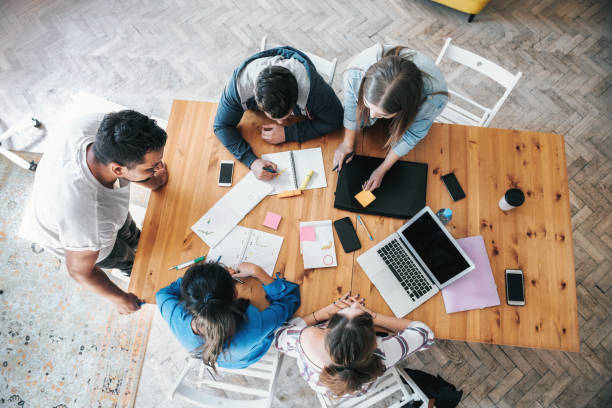 istock overhead view on business people around desk 1210149908