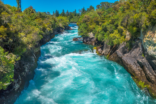 Powerful current of Huka Falls in sunlight, New Zealand. Royalty free stock photo.